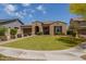 Beautiful home with a well-kept lawn, mature landscaping, and a brick driveway leading to a two-car garage at 2701 N Black Rock Rd, Buckeye, AZ 85396