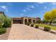 Beautiful property showcasing a brick driveway, a manicured lawn, and mature trees enhancing its curb appeal at 2701 N Black Rock Rd, Buckeye, AZ 85396
