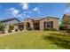 Inviting home with lush green lawn, mature shrubbery, and a brick pathway leading to the front entrance at 2701 N Black Rock Rd, Buckeye, AZ 85396