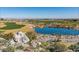 Lush golf course view featuring a serene pond, desert landscaping, and distant mountain scenery at 2701 N Black Rock Rd, Buckeye, AZ 85396