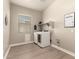 Spacious laundry room with modern appliances, a window, and a decorative laundry-themed wall sign at 2701 N Black Rock Rd, Buckeye, AZ 85396