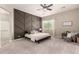 Stylish main bedroom with a modern accent wall, plush carpet, a ceiling fan, and ample natural light at 2701 N Black Rock Rd, Buckeye, AZ 85396