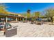 Open-air courtyard featuring ample seating, desert landscaping, and blue umbrellas under a clear sky at 2701 N Black Rock Rd, Buckeye, AZ 85396