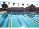 Community pool with lane lines, blue pennant flags, and an adjacent patio at 2701 N Black Rock Rd, Buckeye, AZ 85396