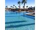 Resort-style community pool with palm trees, lounge chairs, and clear blue water at 2701 N Black Rock Rd, Buckeye, AZ 85396