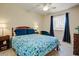 Cozy bedroom featuring a bed with a patterned quilt, a ceiling fan, and dark-out curtains at 2846 E Lupine Ave, Phoenix, AZ 85028