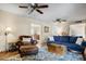 Comfortable living room with ceiling fans, a plush blue sofa, and a leather chair with ottoman at 2846 E Lupine Ave, Phoenix, AZ 85028