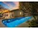 Backyard swimming pool with cool blue water and a ladder for easy access, illuminated by the setting sun at 2846 E Lupine Ave, Phoenix, AZ 85028