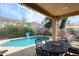 Refreshing backyard pool area featuring a covered patio with string lights and an outdoor dining set at 2886 E Hazeltine Way, Chandler, AZ 85249