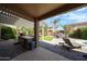 Outdoor kitchen and barbecue area with pergola, built-in grill, artificial grass, and view of the pool at 2886 E Hazeltine Way, Chandler, AZ 85249