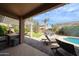Outdoor living space with a covered patio, outdoor kitchen, lush greenery, and a sparkling pool at 2886 E Hazeltine Way, Chandler, AZ 85249