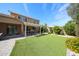 Beautifully landscaped backyard with lush artificial turf, a covered patio, and an outdoor kitchen at 2886 E Hazeltine Way, Chandler, AZ 85249