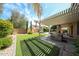Gorgeous backyard featuring an outdoor kitchen, pergola, manicured artificial grass, mature trees, and refreshing pool at 2886 E Hazeltine Way, Chandler, AZ 85249