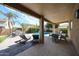 Beautiful outdoor living space with covered patio, pool, lounge chairs, outdoor dining area, and lush greenery at 2886 E Hazeltine Way, Chandler, AZ 85249