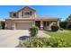 Inviting two-story home with a three-car garage, covered front porch, and colorful flowers at 2886 E Hazeltine Way, Chandler, AZ 85249