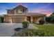 Charming two-story home with a three-car garage, covered porch, and mature landscaping under a colorful sky at 2886 E Hazeltine Way, Chandler, AZ 85249
