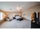 Open main bedroom features plush carpeting, stylish bed, and cozy seating area under ceiling fan at 2886 E Hazeltine Way, Chandler, AZ 85249