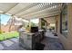 Outdoor kitchen under a pergola with built in grill, countertop, storage, and beautiful backyard at 2886 E Hazeltine Way, Chandler, AZ 85249