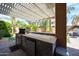 Backyard outdoor kitchen area with built-in grill, cabinets, and counter space under a shaded pergola at 2886 E Hazeltine Way, Chandler, AZ 85249