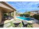 Lush backyard featuring a sparkling pool, lounge chairs, outdoor dining, and landscaped areas at 2886 E Hazeltine Way, Chandler, AZ 85249