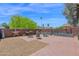 Spacious backyard featuring a brick patio, gravel area, and mature trees, perfect for outdoor enjoyment at 2941 E Nisbet Ct, Phoenix, AZ 85032