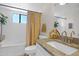 Well-lit bathroom featuring a tub and vanity with decorative mirror at 2941 E Nisbet Ct, Phoenix, AZ 85032