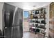 Kitchen featuring stainless steel refrigerator and shelving next to a sunny window at 2941 E Nisbet Ct, Phoenix, AZ 85032