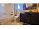Well-lit bathroom featuring a tub-shower combo, dark-wood vanity, and neutral color palette at 29740 N 121St Ave, Peoria, AZ 85383