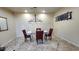 Well-lit dining room featuring a glass table, tile flooring, and modern chandelier at 29740 N 121St Ave, Peoria, AZ 85383
