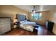 Main bedroom featuring dark wood floors, ceiling fan, and modern furniture at 29740 N 121St Ave, Peoria, AZ 85383