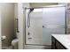 Bright bathroom with a shower-tub combo, frosted glass doors, and tiled flooring at 3065 E Tamarisk St, Gilbert, AZ 85296