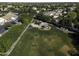This aerial view highlights a community park featuring lush green grass, a playground, and surrounding trees at 3065 E Tamarisk St, Gilbert, AZ 85296
