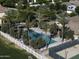 This aerial view shows a stunning community pool, tennis court, and grassy area shaded by palm trees at 3065 E Tamarisk St, Gilbert, AZ 85296