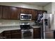 Well-lit kitchen features granite countertops, wood cabinets, and stainless steel appliances at 3065 E Tamarisk St, Gilbert, AZ 85296