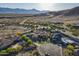 Scenic aerial of a neighborhood featuring a home with mature landscaping, pool, and mountain views in the distance at 3118 W Glenhaven Dr, Phoenix, AZ 85045