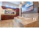 Bright bathroom featuring a central soaking tub with marble detail, wood cabinetry and tile flooring at 3118 W Glenhaven Dr, Phoenix, AZ 85045