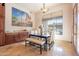 Bright dining room features a chandelier, an outside view, and a dark table with beige seats at 3118 W Glenhaven Dr, Phoenix, AZ 85045