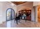 Elegant home entry featuring ironwork doors, a piano, and built-in shelving for refined living at 3118 W Glenhaven Dr, Phoenix, AZ 85045