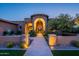 Stunning front entrance featuring a stone archway, elegant lighting, and lush desert landscaping at 3118 W Glenhaven Dr, Phoenix, AZ 85045