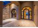 Ornate iron gate entry to courtyard with custom tiled floor. Decorative sconces and water feature at 3118 W Glenhaven Dr, Phoenix, AZ 85045