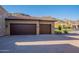 Spacious two-car garage with brown doors, set against a backdrop of mountains and desert landscaping at 3118 W Glenhaven Dr, Phoenix, AZ 85045