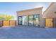 Detached garage with large windows and a wooden gate, complemented by a brick driveway and desert landscape at 3118 W Glenhaven Dr, Phoenix, AZ 85045
