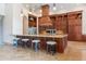 Gourmet kitchen island with granite countertops, seating, and custom wood cabinetry at 3118 W Glenhaven Dr, Phoenix, AZ 85045