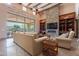 Elegant living room with stone fireplace, wooden beams, built-in shelves and large windows offering outdoor views at 3118 W Glenhaven Dr, Phoenix, AZ 85045