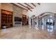 Open living space with stone fireplace, arched doorways, and travertine tile flooring throughout at 3118 W Glenhaven Dr, Phoenix, AZ 85045