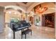 Elegant living space featuring a piano, custom ceiling fixture, and open layout for sophisticated living at 3118 W Glenhaven Dr, Phoenix, AZ 85045