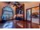 Home office with custom bookcase, exercise equipment, and natural light creates an inviting, functional workspace at 3118 W Glenhaven Dr, Phoenix, AZ 85045