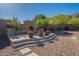 Beautiful stone and stucco outdoor fireplace featuring tiled steps and lush desert landscaping at 3118 W Glenhaven Dr, Phoenix, AZ 85045