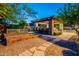 Stone outdoor kitchen and bar area with grill, bar seating and garden area at 3118 W Glenhaven Dr, Phoenix, AZ 85045