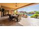 Covered patio showcases comfortable dining area overlooking the pristine pool and relaxing outdoor living space at 3118 W Glenhaven Dr, Phoenix, AZ 85045